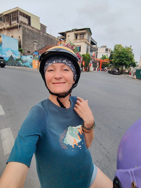 Woman rides motorcycle through decorated Hong Gai Ward street
