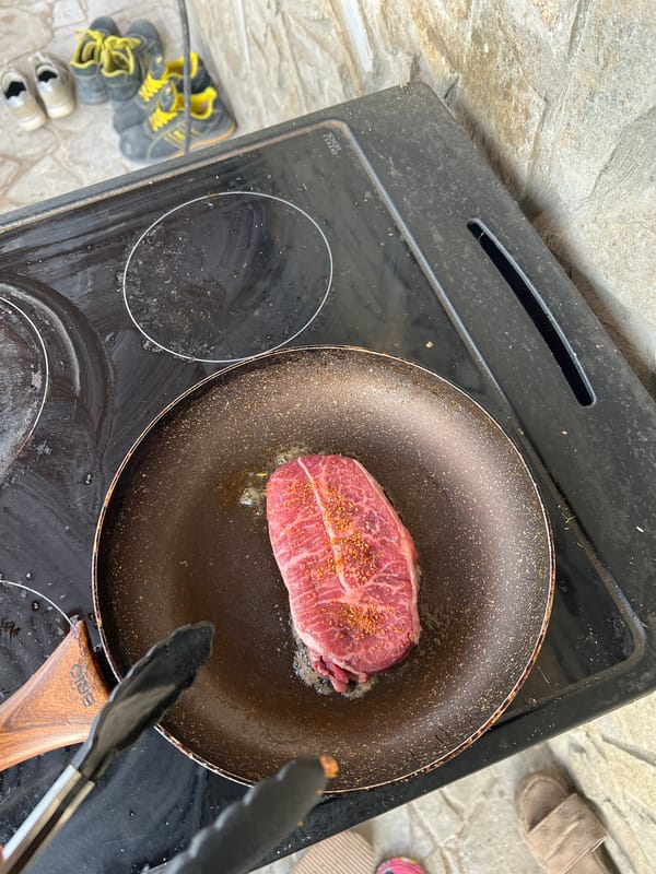 Man cooks steak outdoors in Shumata, Bulgaria