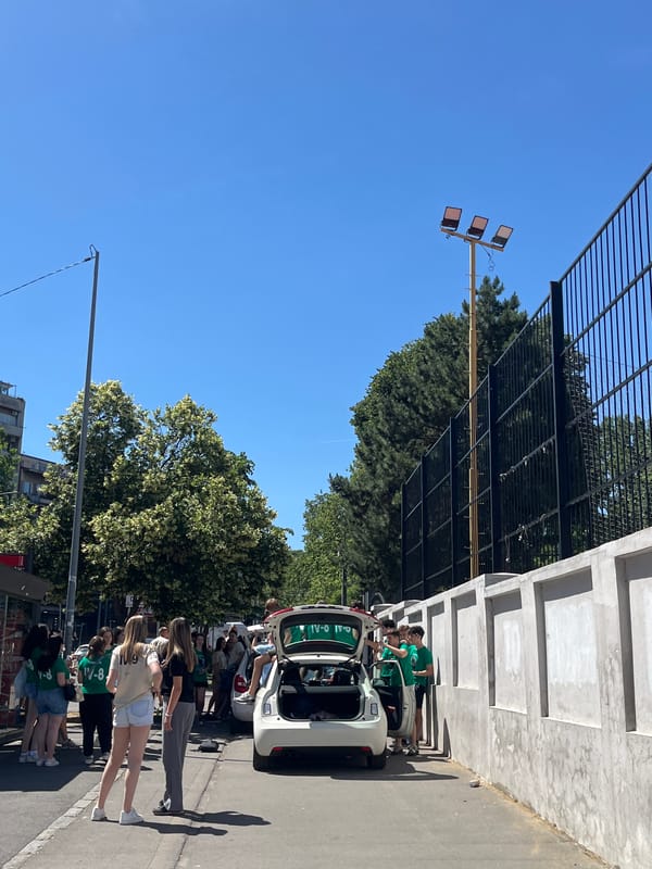 Group in matching shirts gathers around car in Belgrade