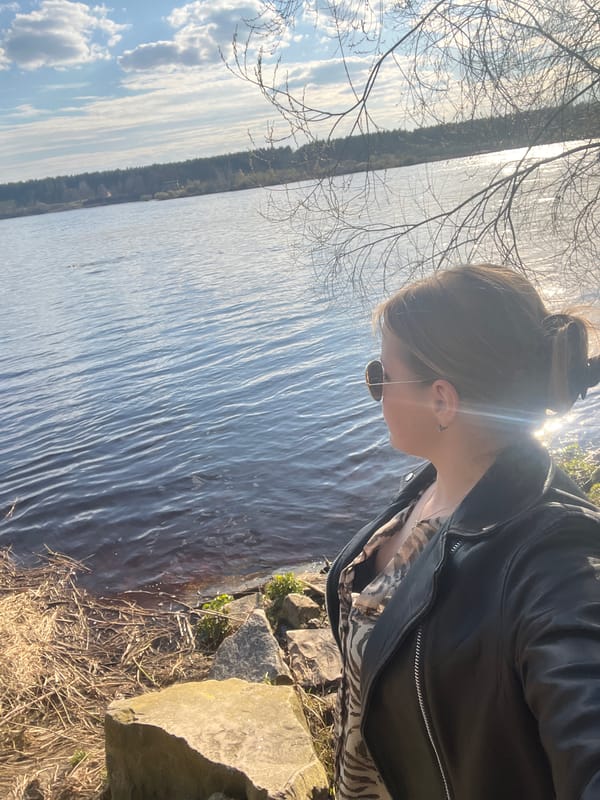 Woman photographs herself at Riga waterfront during afternoon outing