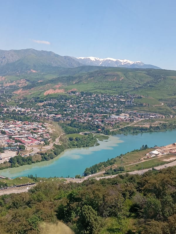 Aerial view captures Chinarkent valley with turquoise river, highway