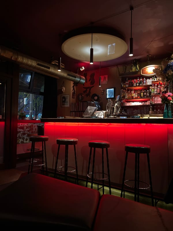 Berlin bar patrons gather amid retro decor, roller skate projections
