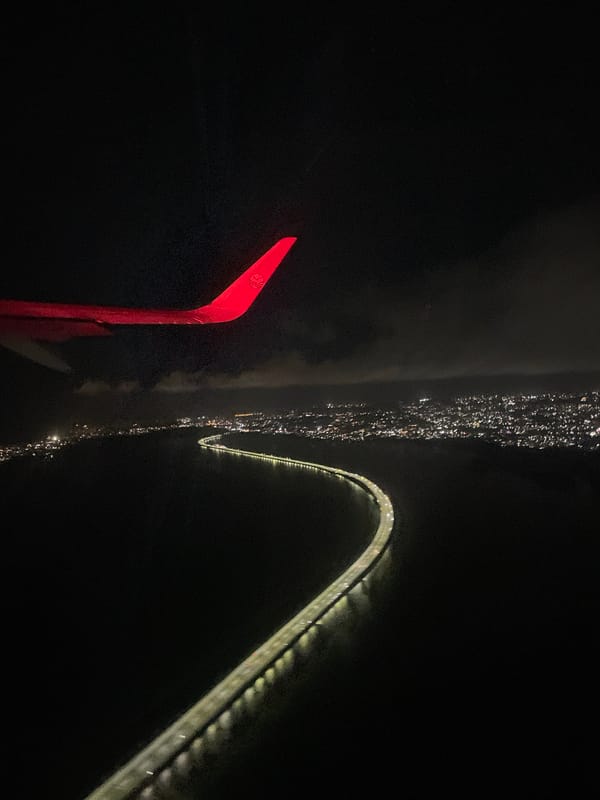 Illuminated bridge and aircraft wing observed in Kuta nighttime scene