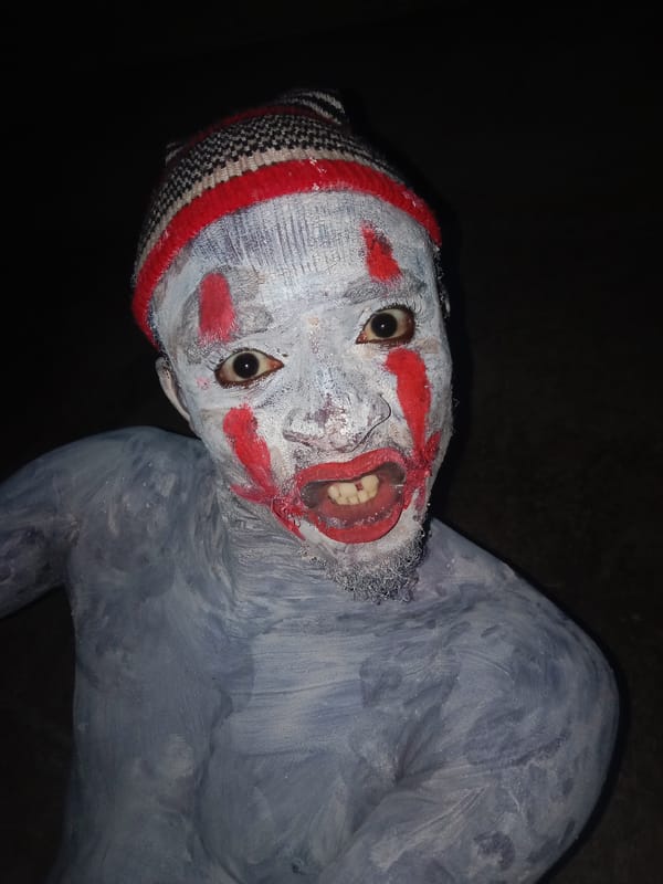 Person in clown makeup and striped hat documented making gestures