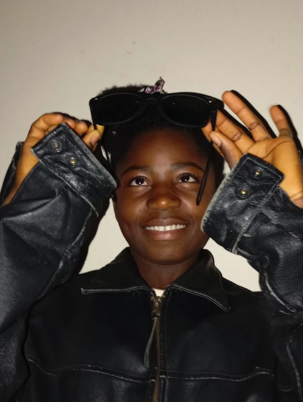 Person in leather jacket poses with sunglasses in Jos