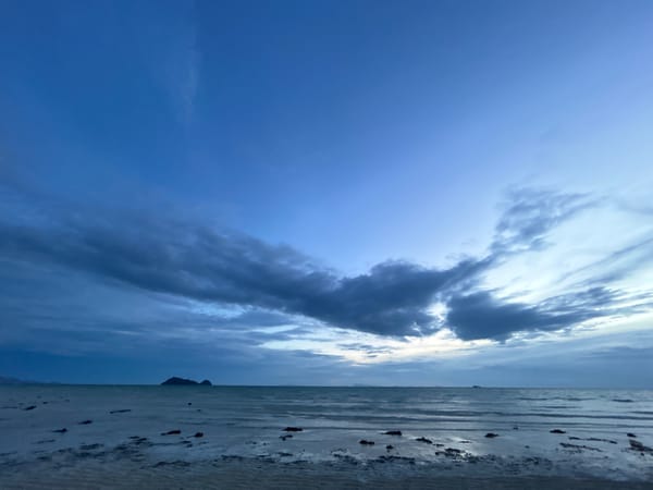 Dusk on a Ko Pha-ngan beach, moody skies and shoreline activity