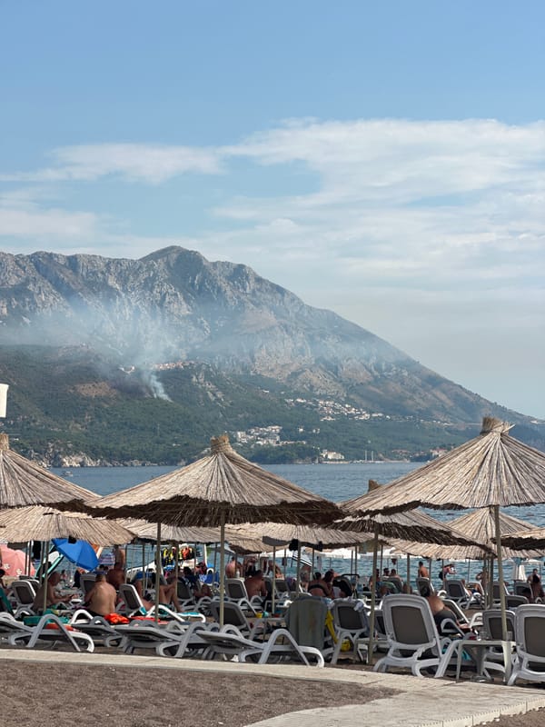 Wildfire smoke rises over Boreti beach on a busy summer day