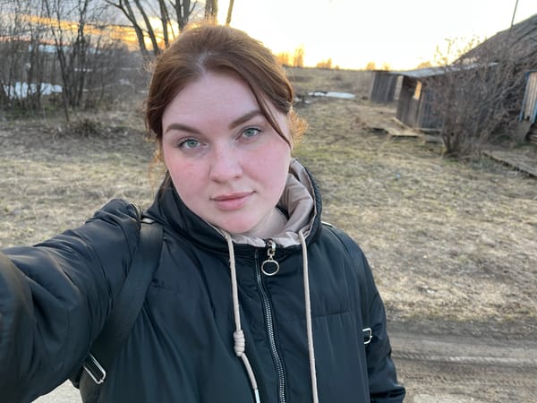 Woman takes selfies in rural Pavlovka under cloudy skies