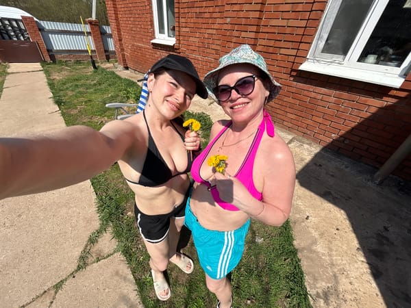 Women sunbathe and photograph outdoors in Rusalevka, Russia