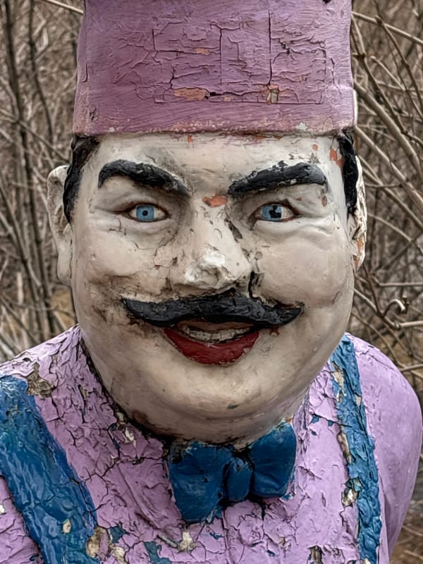 Weathered chef statue documented by witnesses in park setting
