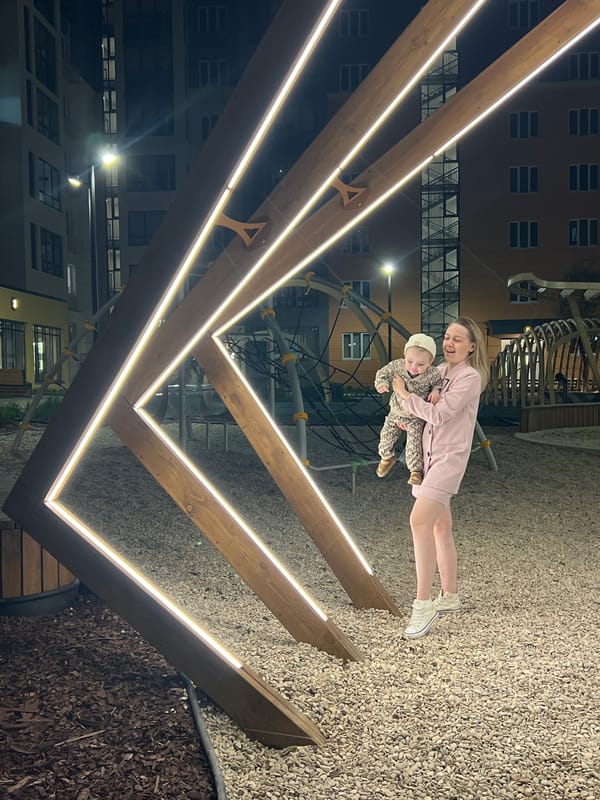 Mother and child visit illuminated playground in Pervomaysky