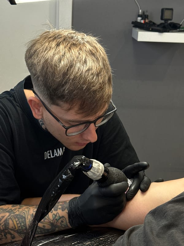 Tattoo artist works on bird design in Yaiza shop