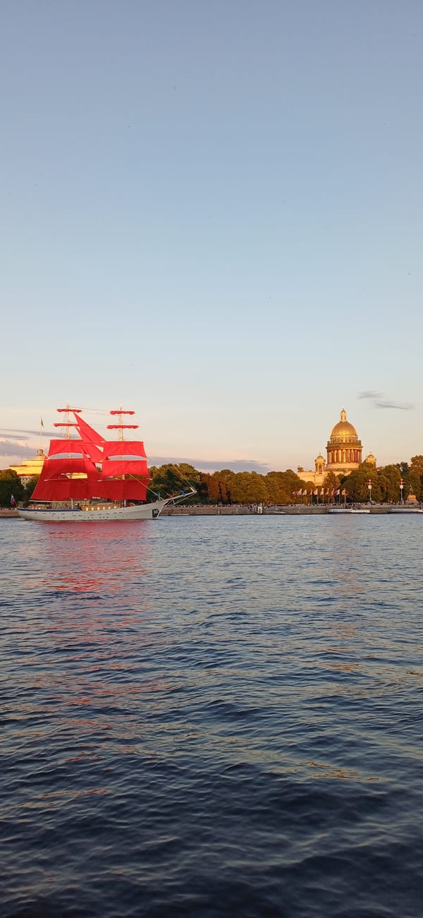 Red-sailed ship draws crowds during sunset passage through Saint Petersburg