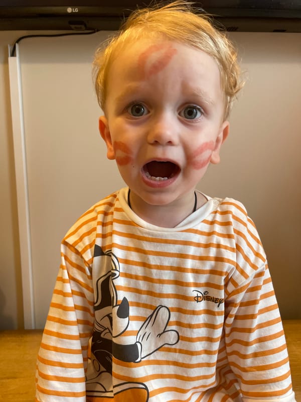 Child photographed with lipstick marks on face and cheek