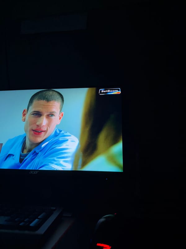 Computer monitor displays man in blue shirt with BetBoom logo