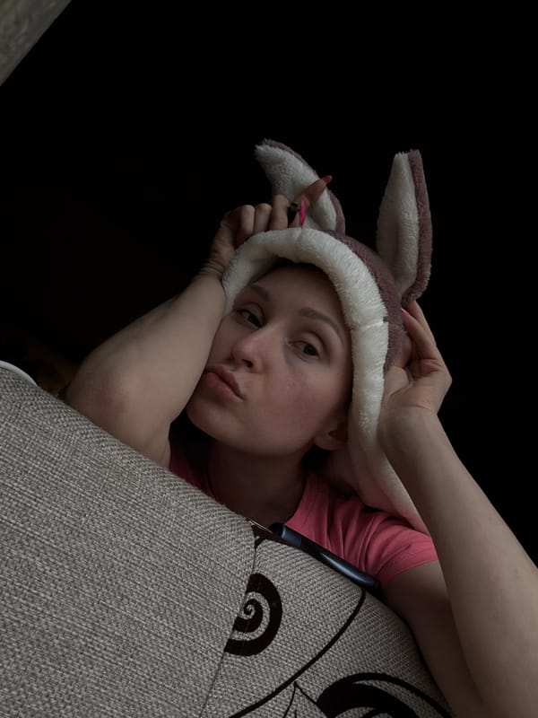 Person in rabbit-ear hat rests on couch in Russia
