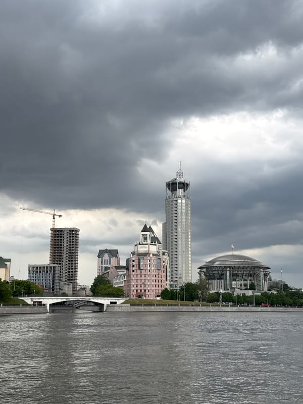 Passenger boats docked along Moscow River under cloudy skies