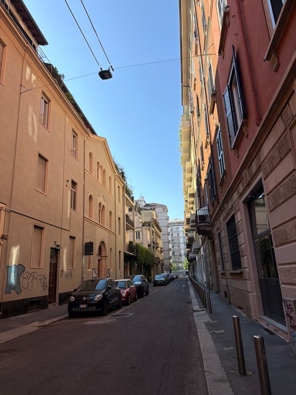 Milan street scene captured showing parked cars, varied architecture