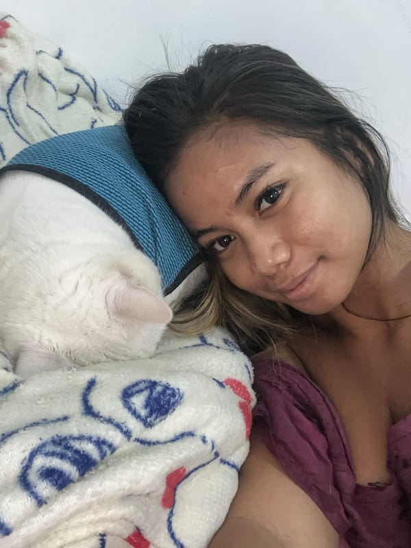 Woman and cat share quiet moments in Sukawati bedroom