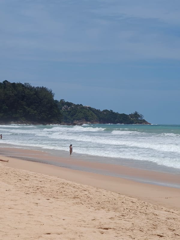 Red flag on a quiet Sakhu beach, calm morning waves