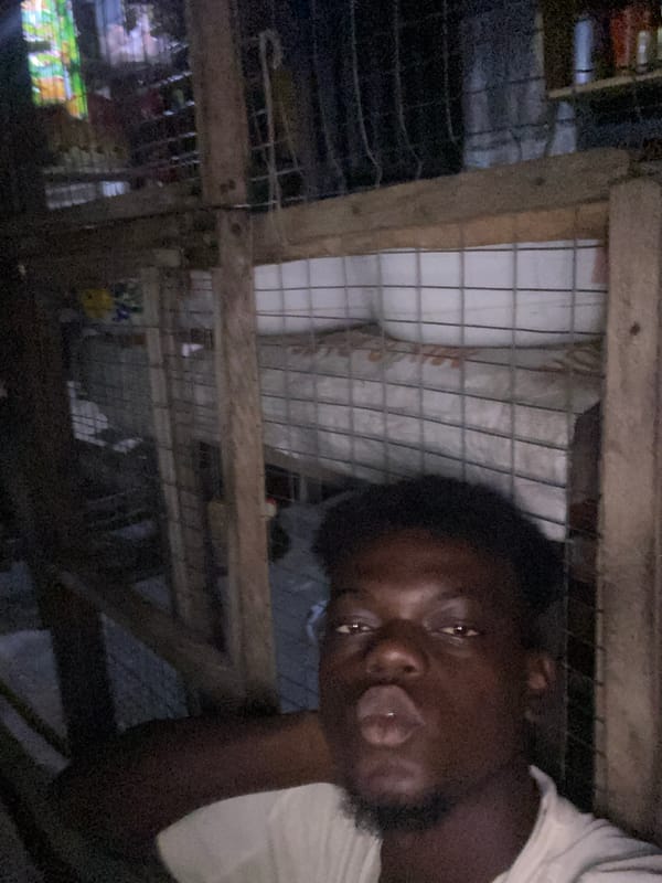 Man documented inside makeshift wooden enclosure, location unknown