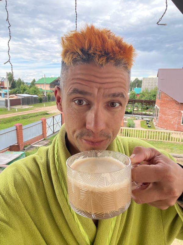 Orange hair, green robe, frothy drink — lazy afternoon in Chaikovsky