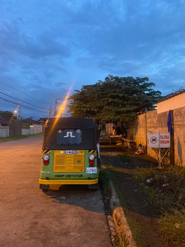 Davao City street at dusk, vehicles parked along a residential road