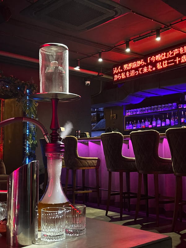 Neon-lit hookah lounge in Kazan with robotic decor and Japanese signage