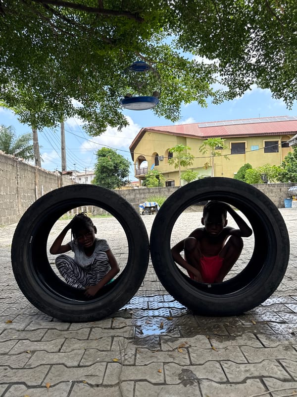 Children play in car tires during outdoor recreation in Ado