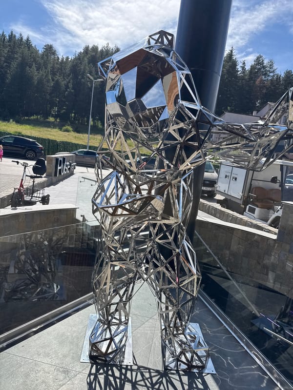 Geometric bear sculpture and casual moments captured around outdoor plaza