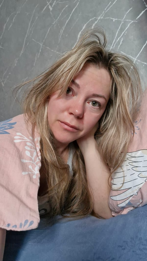 Woman rests on floor with patterned pillow in Otchor