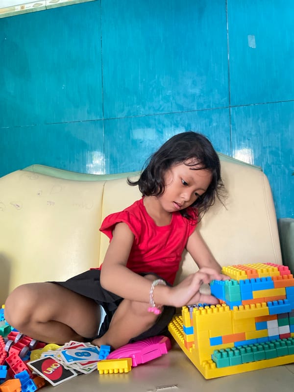 Young girl plays with toys during early hours in Gelam