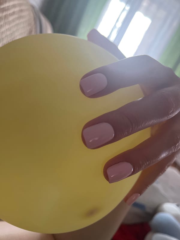 Yellow balloon held close, soft indoor light, Vladikavkaz