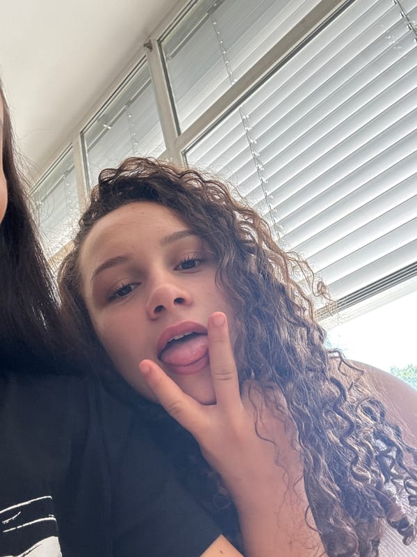 Young women take playful morning selfies indoors