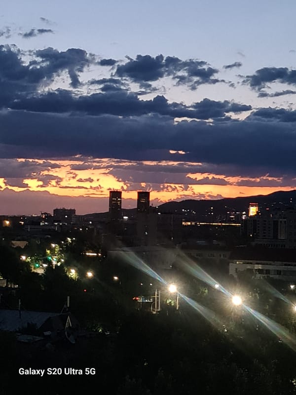 Almaty skyline transitions from sunset to nightfall