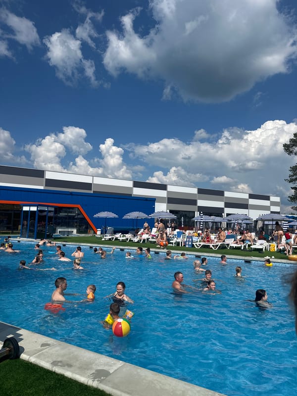 Families enjoy sunny summer day at crowded outdoor pool