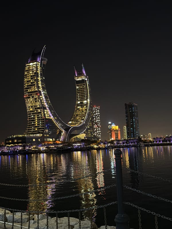 Katara Towers illuminate night sky with purple, yellow lights