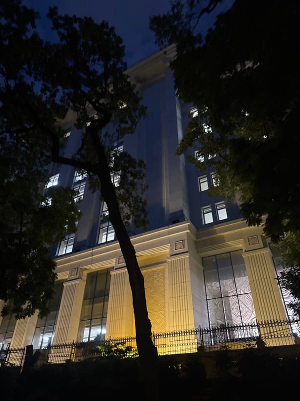 Hanoi park at dusk: ancient roots, stone paths, colonial backdrop