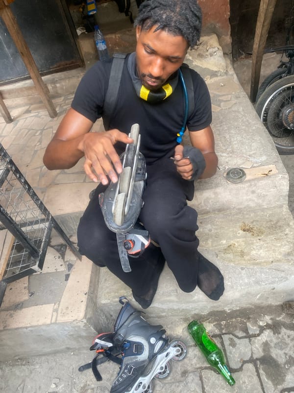 Man handles inline skating gear on Lagos concrete steps