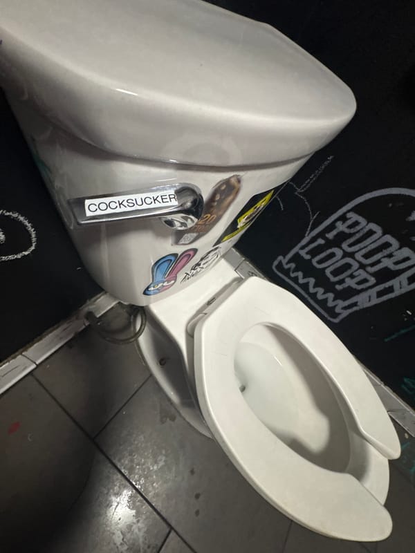Vandalized restroom documented in Las Vegas with graffiti and stickers