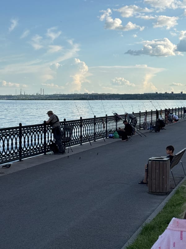 Waterfront promenade bustles with families, performers, boaters during afternoon