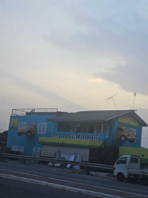 Colorfully painted building with car murals observed in Accra