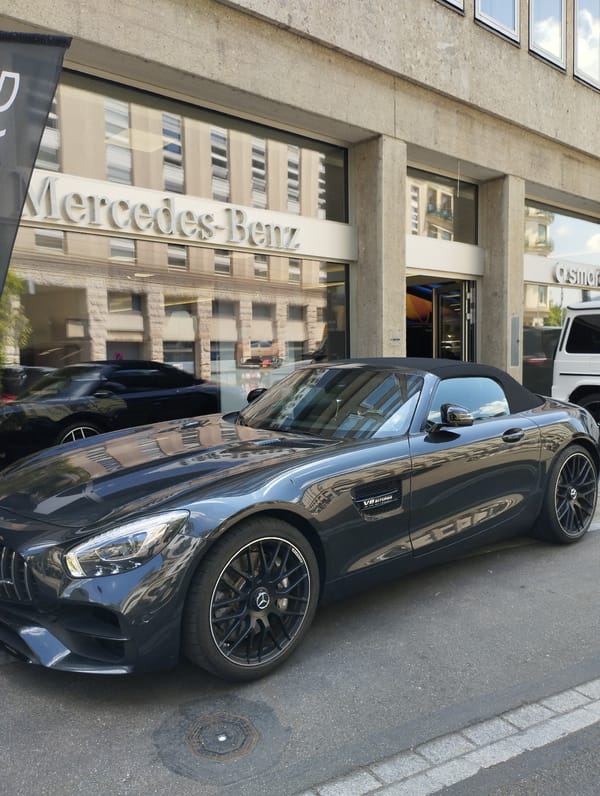 Scooters and Mercedes convertibles outside a Zurich dealership