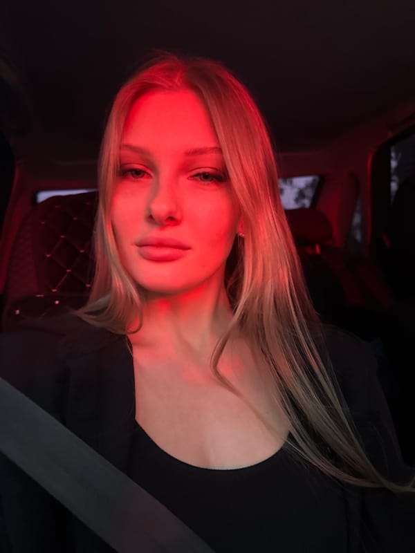 Woman photographed in car interior using smartphone in Perm