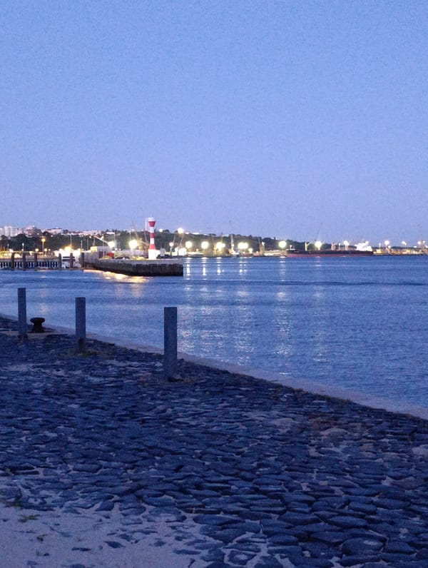 Setúbal waterfront at dusk — bay, monuments, and city lights