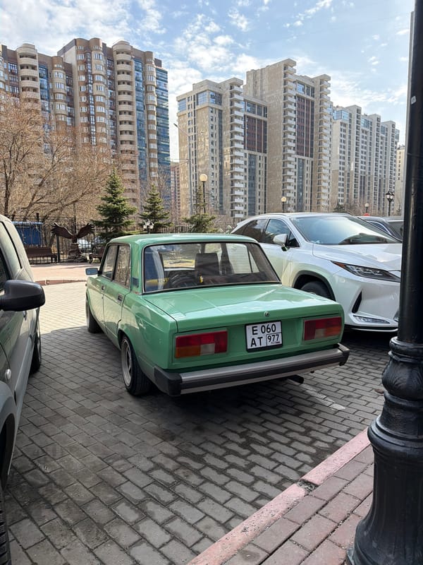 Green Lada parked on Moscow street amid residential buildings