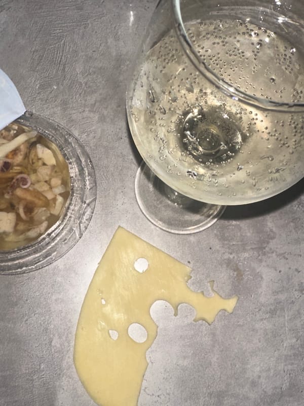 Woman enjoys sparkling wine and snacks at home in Chaikovsky