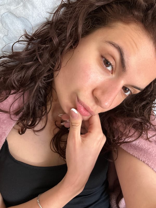 Woman poses thoughtfully with finger to lips at dawn
