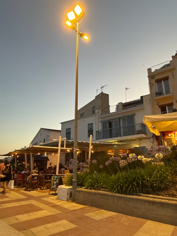 Blanes beach and promenade at dusk, boats and evening crowds