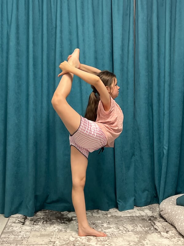 Young gymnast practices acrobatic moves at home in Chaikovsky